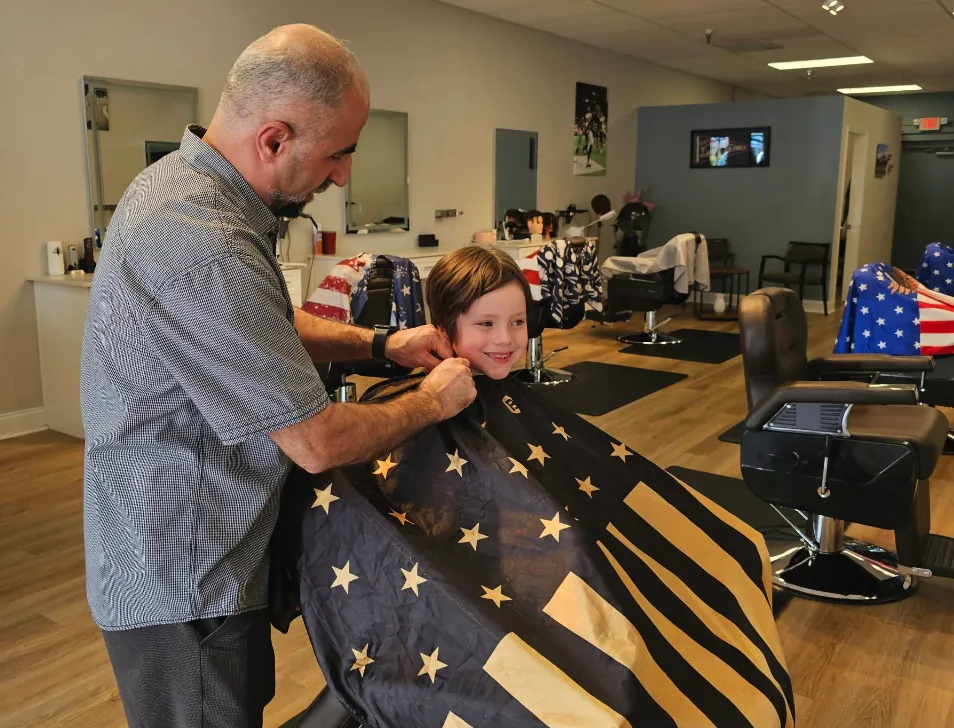 Hasim finishing a kids haircut